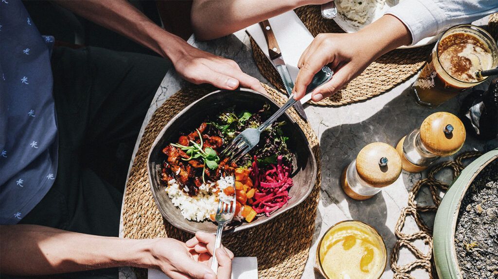 Bowl with healthy food. Fresh vegetables, beef and rice in a big plate. Sunny day, serving a meal in a cafe.