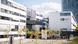 Photo of Deutsche Welle's location in Bonn on a sunny day. The building is white and has many windows.