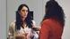 A participant in the statement training speaks into a microphone that the media trainer holds out to her.