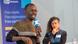 Maxence Melo man speaks into a DW microphone as a woman looks at him from the stage