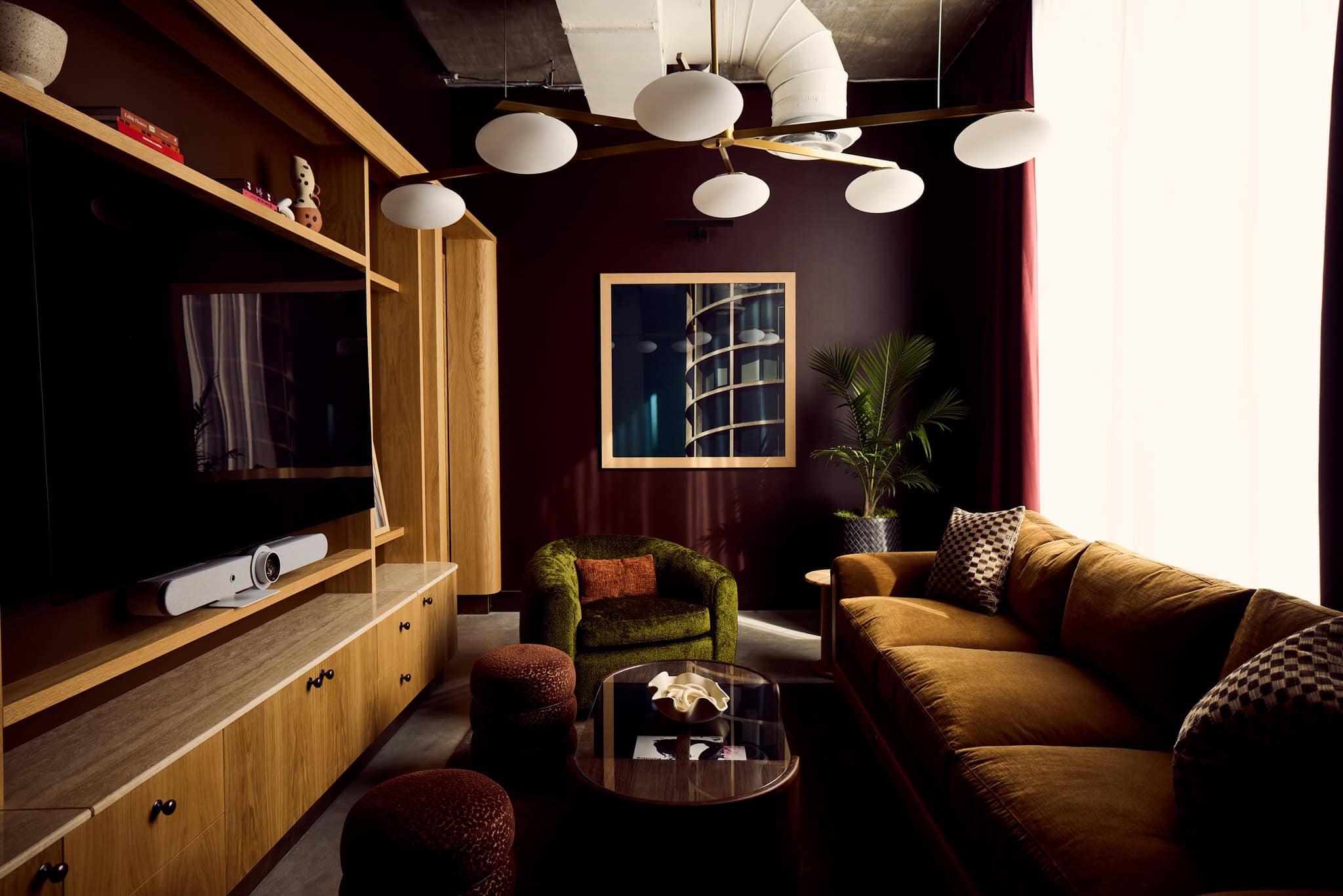 Residential-feel library lounge with rich tones and AV setup in East Austin