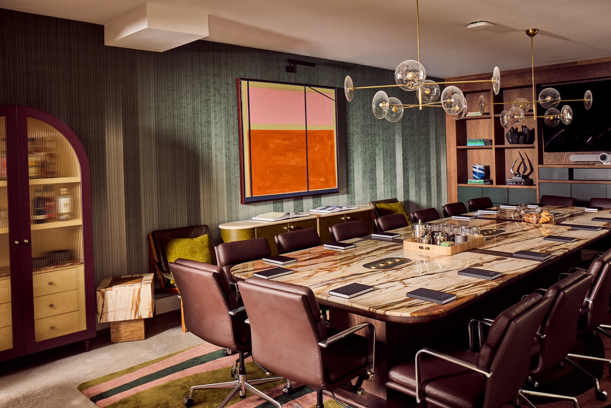 Design-forward meeting room with marble table and leather chairs at The Malin East Austin
