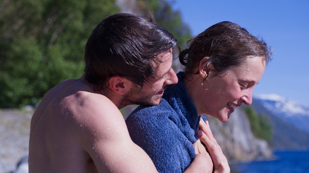 Mathieu (Gaspard Ulliel) umarmt Hélène (Vicky Krieps) nach dem Schwimmen im Fjord. | Bild: Eaux Vives Productions /NiKo Film/Yves Cape