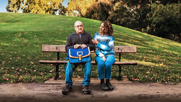 Alice (Julia Piaton) unterrichtet den 65-jährigen Analphabeten Émile (Michel Blanc).
| Bild: BR/Happy Entertainment/Stephanie Branchu; Montage: BR; Hintergrund mit KI bearbeitet
