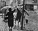 Durch die Grenze getrennte Frauen reichen eine Tasche über Stacheldraht Durch die Grenze getrennte Frauen reichen eine Tasche über Stacheldraht