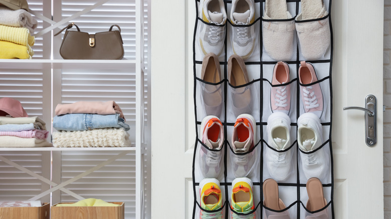 A hanging organizer on a door with shoes in it