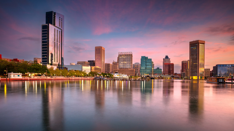 The Baltimore city skyline reflected over the harbor at dusk.