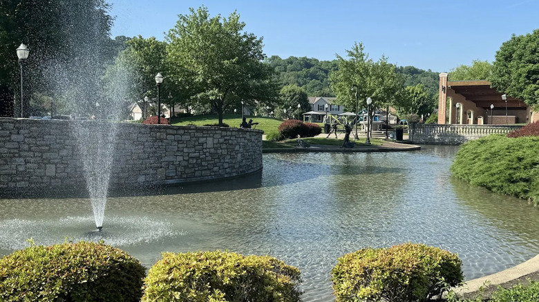 View of fountain, pond, playground, and walking paths at Village Green Park in Fairfield, Ohio.