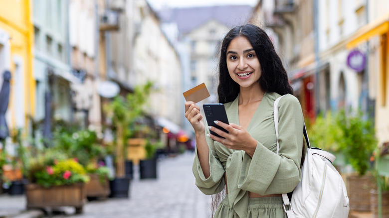 Woman holding credit card in European city
