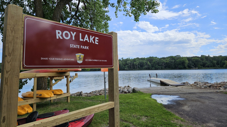A scene of Roy Lake with a sign reading "Roy Lake State Park" in the foreground