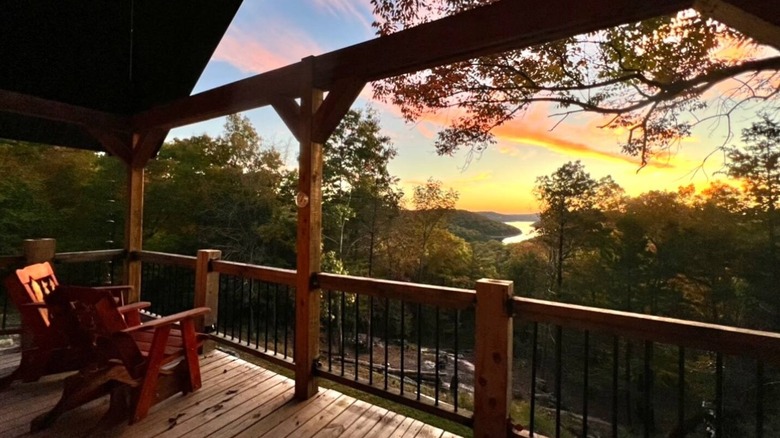 a view of the sunrise and a lake in the valley below from the deck of a cabin in the Ozark Mountains