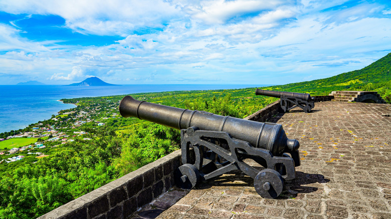 An old cannon on top of Brimstone Hill Fortress on St. Kitts, with a view overlooking the sea and neighboring islands