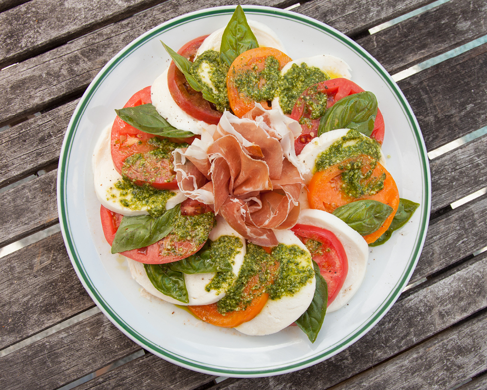 Heirloom tomato and prosciutto caprese with pesto vinaigrette