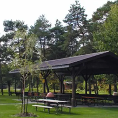 Covered picnic shelter with picnic tables and shade trees