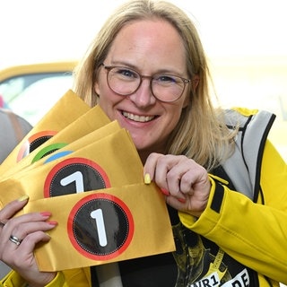 Melanie aus dem SWR1 Team hält die goldenen Umschläge für die Hitparade in der Hand | Bewerbt euch als SWR1 Hitparaden-Platzansager