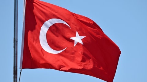 Eine türkische Flagge weht vor blauem Himmel (Symbolbild): Ein Ulmer Familienvater ist beim Urlaub in der Türkei verhaftet worden. Ihm wird  von der türkischen Staatsanwaltschaft die Mitgliedschaft in einer terroristischen Gruppe vorgeworfen. 