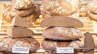 Brote, auch halbe Brote, liegen in der Auslage einer Bäckerei.
