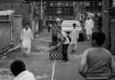 Cricket in the street by John Bolloten