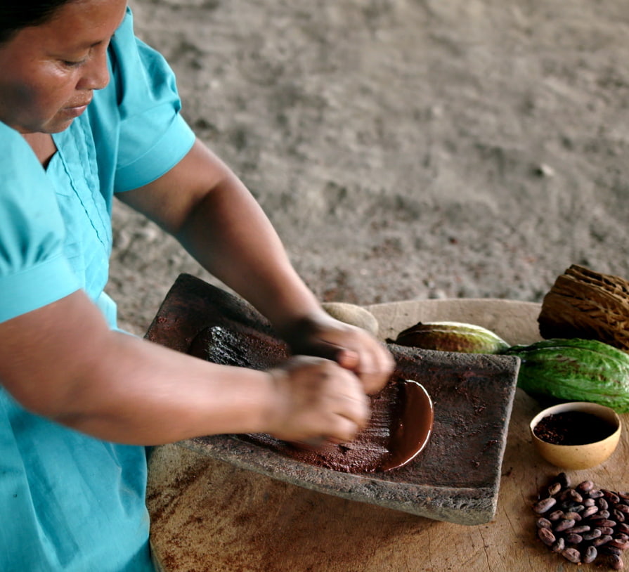 Mulher de Belize produzindo chocolate maia