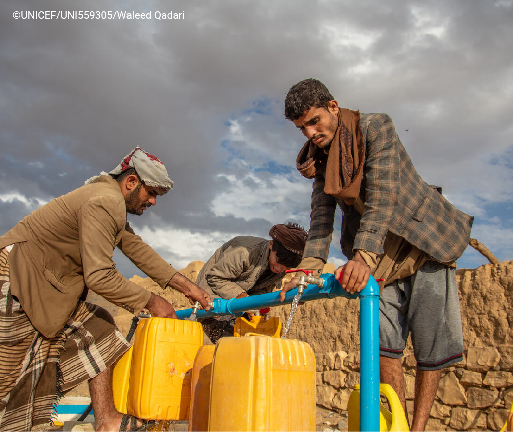 Men collecting water from a pipe line