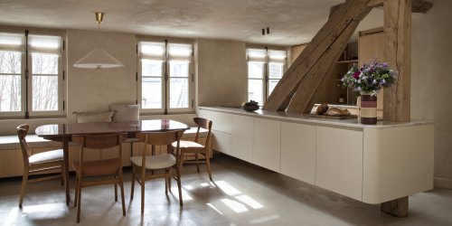 salle à manger et cuisine ouverte avec mur à la chaux