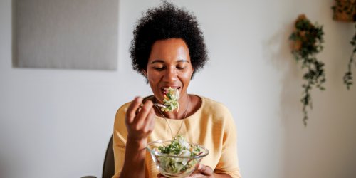 Femme mangeant des légumes verts