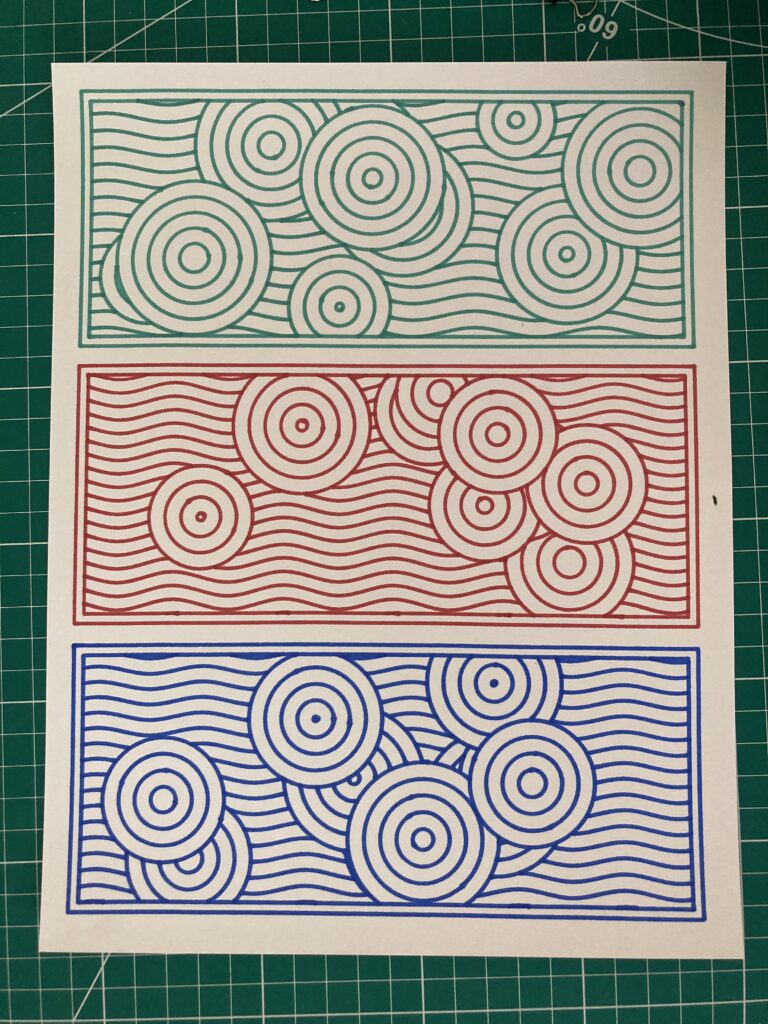 Three different framed geometric circle patterns: One in green, one in red, and one in blue. On white paper.