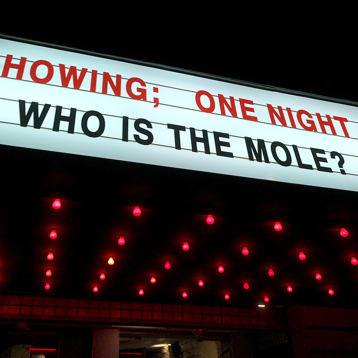 A marquee that reads 'NOW SHOWING; ONE NIGHT ONLY WHO IS THE MOLE?'