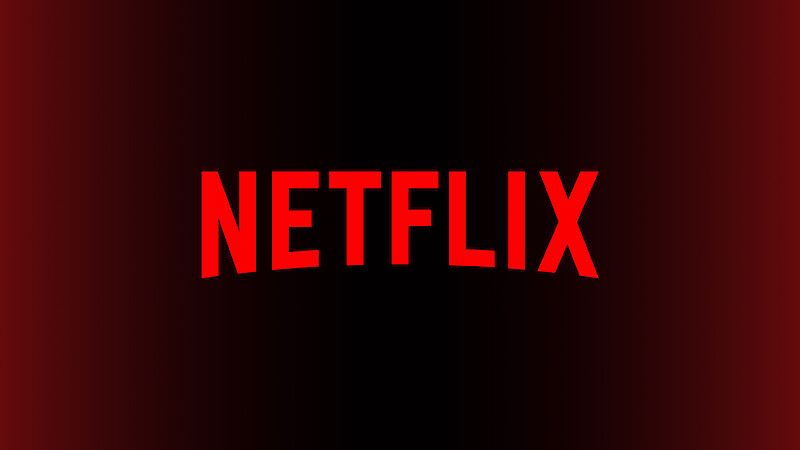 Logo da Netflix em vermelho, centralizado sobre um fundo em degradê preto e vermelho, representando a identidade visual do serviço de streaming.