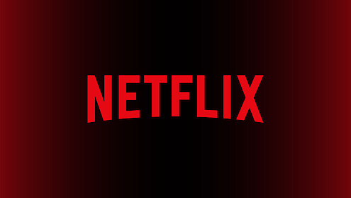 Letra “N” grande e vermelha no centro de um fundo preto com um degradê em vermelho, representando o logo da Netflix.