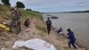 资料照片：2018年12月27日，泰国救援人员在泰国曼谷东北部的呵叻拍侬省湄公河岸边覆盖一具尸体。警方于2019年1月22日表示，DNA测试显示，在泰国湄公河岸边发现的两具尸体是反政府活动人士的尸体，怀疑是政治杀戮。（美联社照片）
