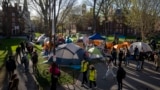 在马萨诸塞州剑桥市哈佛大学的一个营地，可以看到抗议加沙战争的学生和穿过哈佛园(Harvard Yard)的路人。抗议以色列和哈马斯战争的哈参与者宣布，他们将自愿结束对哈佛园的占领。（资料图片：2024年4月25日）