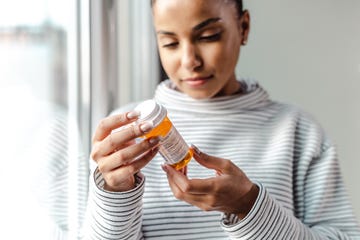 A serious young woman holding a bottle of medicines A serious young woman holding a bottle of medicines