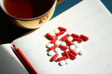 Medicine And Healthcare, Heap Of Red Iron Capsules And White Painkiller Pills Against Daily Calendar Background Medicine And Healthcare, Heap Of Red Iron Capsules And White Painkiller Pills Against Daily Calendar Background