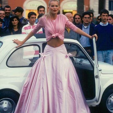 Look rosa anni Novanta look anni novanta con cardigan rosa annodato e maxi gonna in taffetà rosa, simbolo del romanticismo della moda italiana.