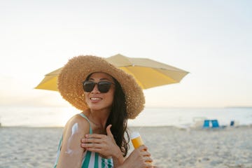 An Asian woman applying sunscreen at the beach An Asian woman applying sunscreen at the beach