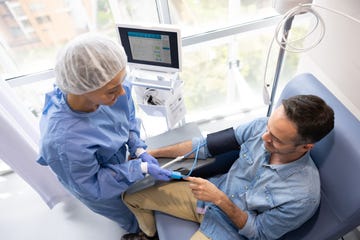 Nurse placing a pulse oximeter on the finger of a patient Nurse placing a pulse oximeter on the finger of a patient