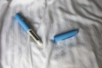 Blue Insulin Pen On Bed With Cap Removed, Diabetes Injection Device For Home Care glp-1 medication