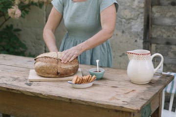 Mature woman checking loaf of bread at back yard Mature woman checking loaf of bread at back yard