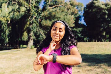 Front view portrait of a brunette latin american sport woman, measuring taking her pulse with a smart watch. doctors explain dangerous heart rate - Front view portrait of a brunette latin american sport woman, measuring taking her pulse with a smart watch.