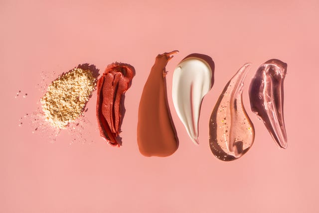 beauty prevention Row of smears of assorted cosmetic products and face powder on pink background. Trendy selfcare products of the year beauty prevention top view of beige face powder and multicolor strokes of various cosmetic products smeared on pink background good for your design