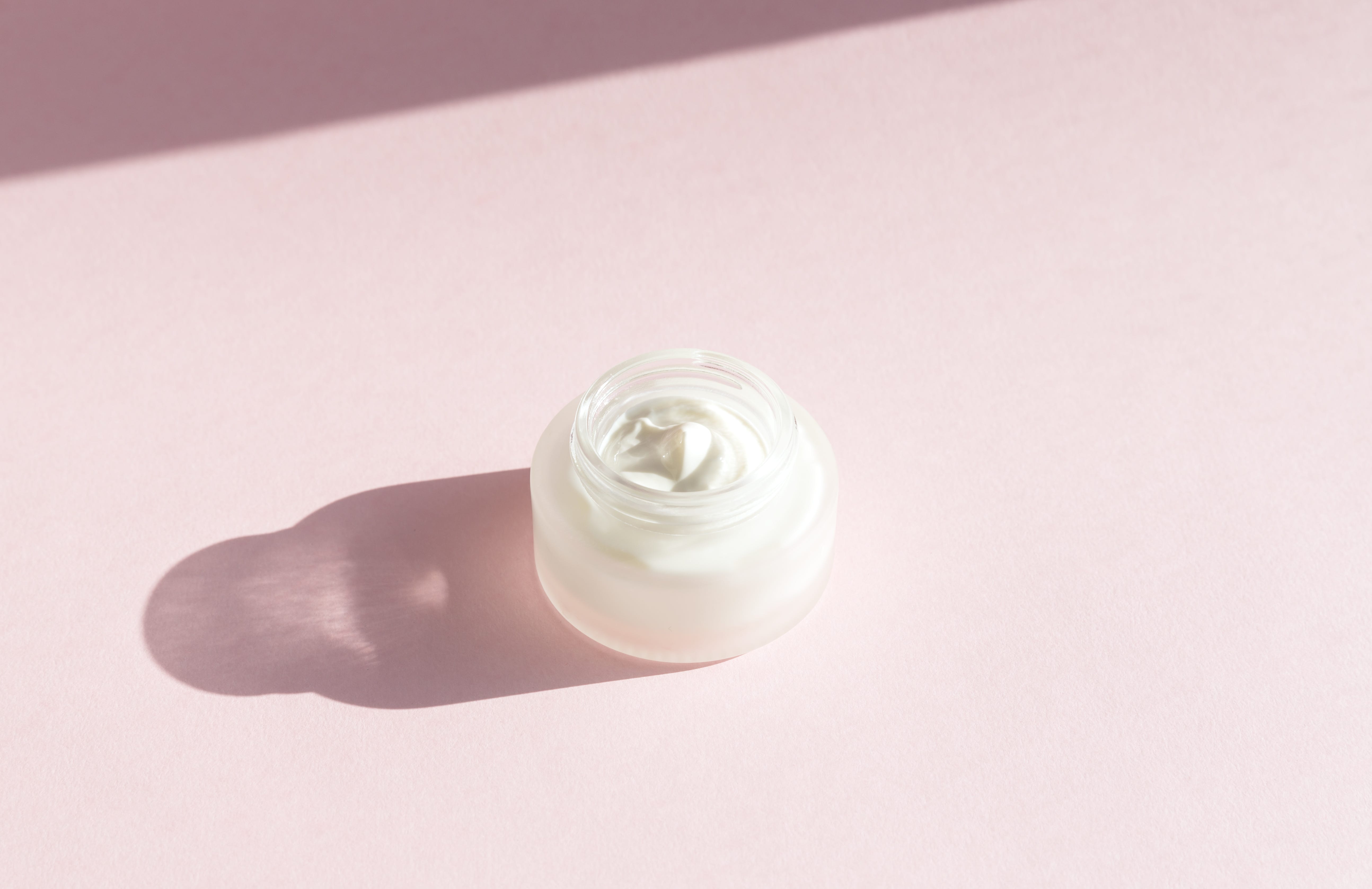 how to look younger Cosmetic cream on a pink background. Hard shadows. how to look younger cosmetic cream on a pink background