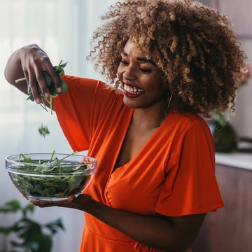 Healthy Summer Vegan Recipes: Smiling Black Woman Preparing a Smoothie in the Kitchen Healthy Summer Vegan Recipes: Smiling Black Woman Preparing a Smoothie in the Kitchen