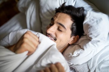 male sex toys - Man sleeping comfortably in bed smiling young man sleeping comfortably in bed at home