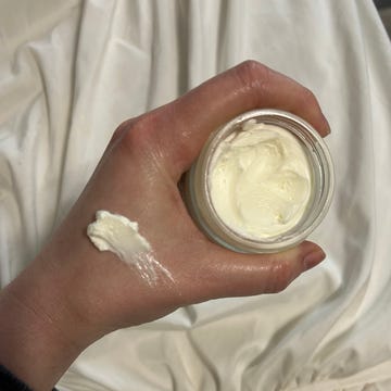 beef tallow for skin hand holding a jar of cream with a small amount applied on the wrist