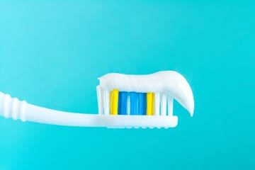 Toothpaste on a toothbrush close-up on a blue background swollen gums