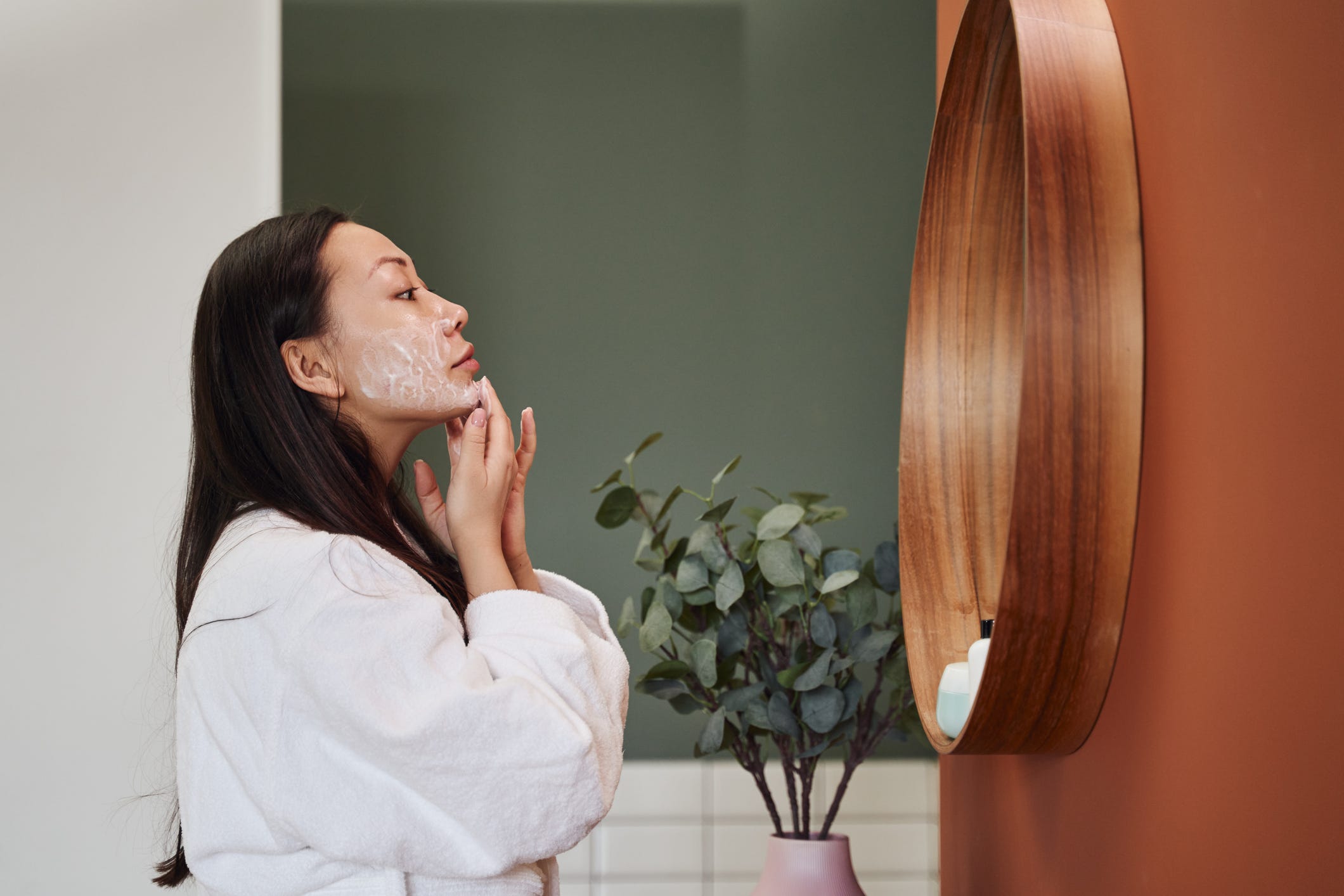 Young Asian woman applying moisture cream at her face young asian woman applying moisture cream at her face