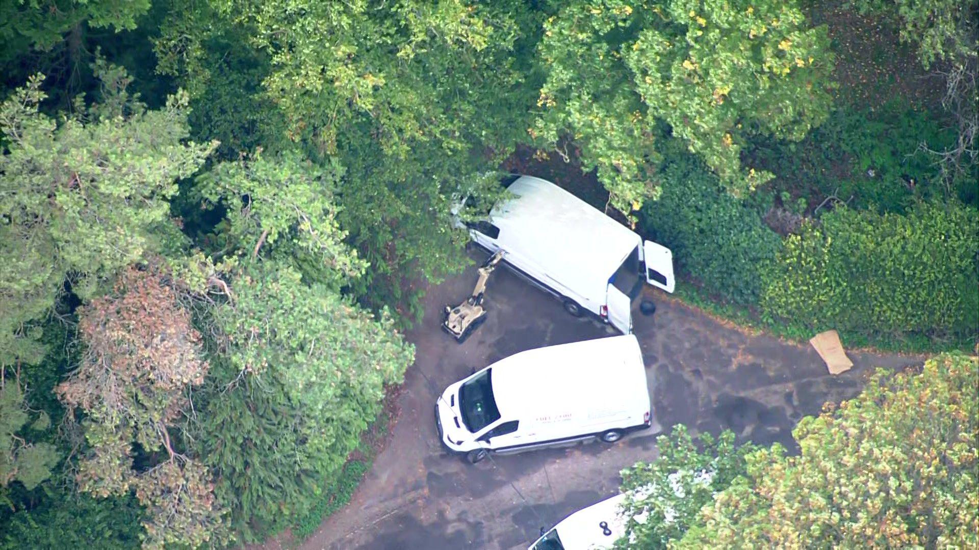 Aerial view of vans with robots on wheels nearby.