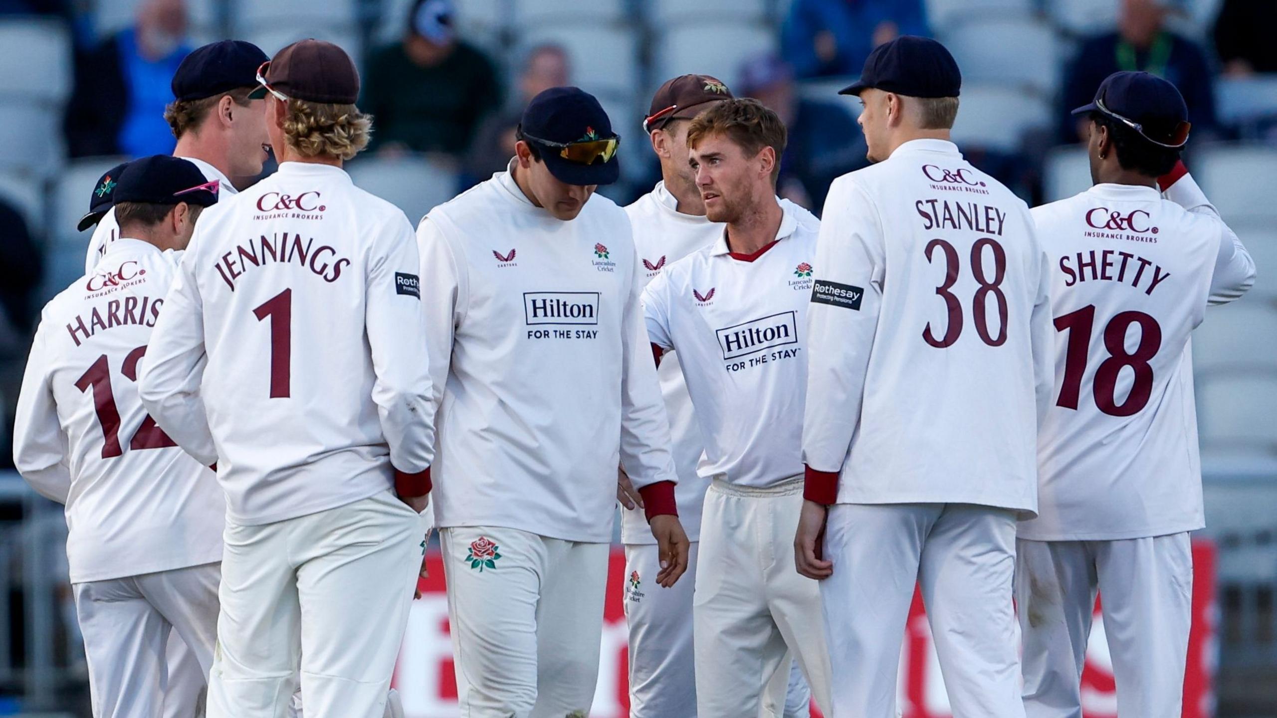 Lancashire players all gathered round George Balderson after he took a wicket in a match at Old Trafford