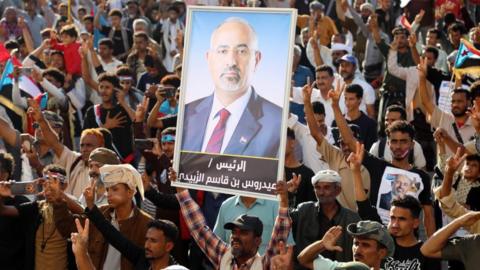 A person holds up a picture of Aidarous Al-Zubaidi during a rally in the southern port city of Aden